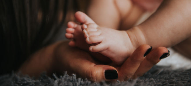Woman holding babies feet