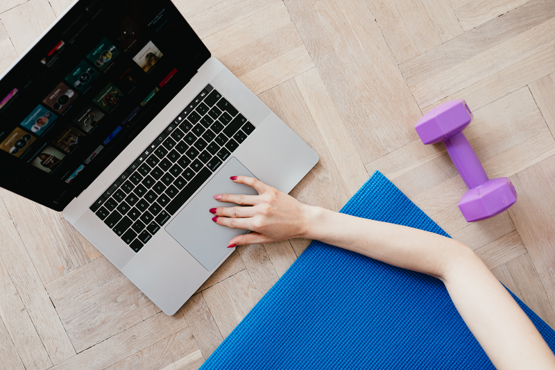 Person using online fitness coaching site on laptop